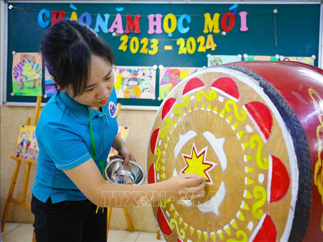 Cô giáo Trường Tiểu học Bình Minh (Hà Nội) vẽ trang trí lại mặt trống, sẵn sàng cho ngày khai trường. Ảnh: Thanh Tùng - TTXVN
