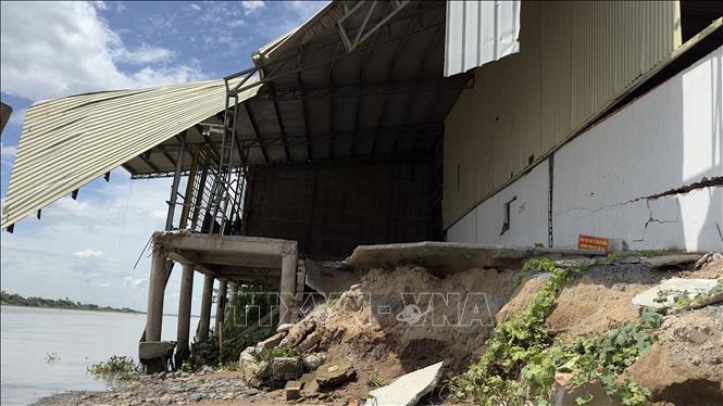 Một kho hàng bị thiệt hại nặng do sạt lở bờ sông Hậu qua địa bàn huyện Châu Phú, An Giang. Ảnh: Thanh Sang -TTXVN