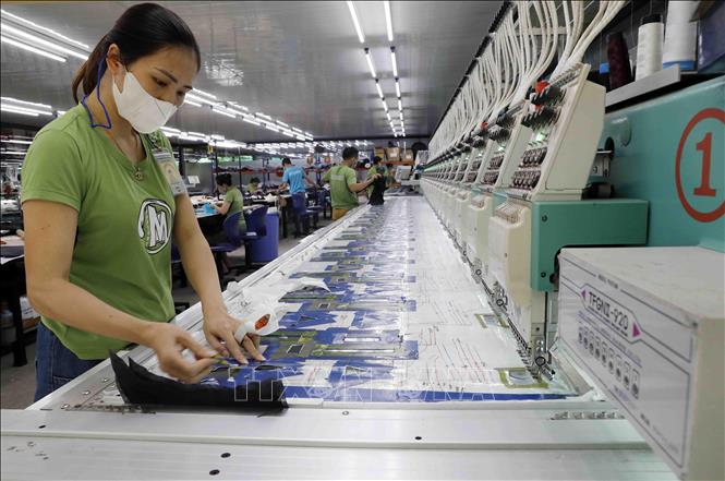 Thêu mác trên quần áo xuất khẩu tại Công ty Maxport Thái Bình. Ảnh: Trần Việt - TTXVN