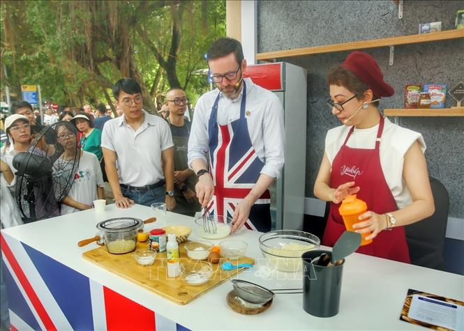 Đại sứ Vương quốc Anh tại Việt Nam Iain Frew vừa giới thiệu vừa làm bánh scones, một loại bánh nướng truyền thống của Anh. Ảnh: Tuấn Đức - TTXVN
