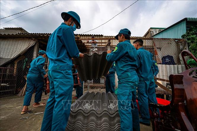 Lực lượng dân quân địa phương hỗ trợ người dân sửa chữa nhà cửa. Ảnh: TTXVN phát