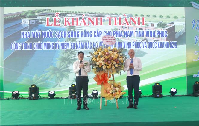Chủ tịch UBND tỉnh Vĩnh Phúc Lê Duy Thành (trái) tặng hoa chúc mừng Chủ đầu tư của dự án Nhà máy nước sạch Sông Hồng Vũ Trường Sinh tại buổi lễ. Ảnh: Hoàng Hùng – TTXVN