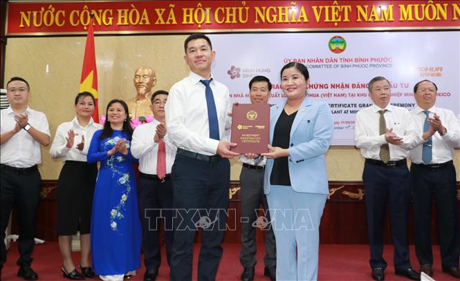 Chủ tịch UBND tỉnh Bình Phước Trần Tuệ Hiền trao Giấy chứng nhận đầu tư cho Chủ tịch Công ty TNHH SHANDONG HAOHUA TIRE. Ảnh: Sỹ Tuyên - TTXVN