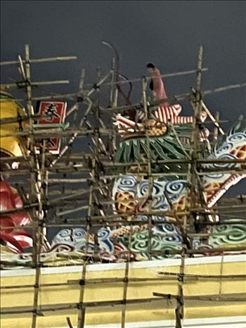 Người phụ nữ lên khu vực cao nhất của cổng chánh môn Tòa thánh Cao đài Tây Ninh tối 12/9. Ảnh: Minh Phú - TTXVN