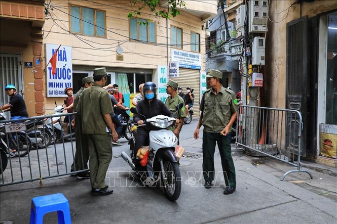 Các lực lượng chức năng lập hàng rào ngăn các phương tiện di chuyển vào trong khu vực phong tỏa. Ảnh: Tuấn Anh - TTXVN