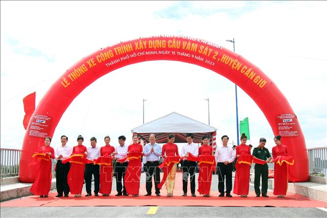 Các đại biểu thực hiện nghi thức thông xe cầu Vàm Sát 2. Ảnh: Tiến Lực - TTXVN