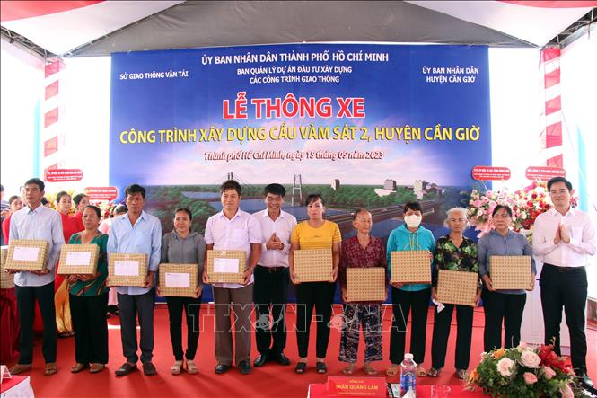 Tặng quà cho các hộ dân bàn giao đất để xây dựng cầu Vàm Sát 2. Ảnh: Tiến Lực - TTXVN