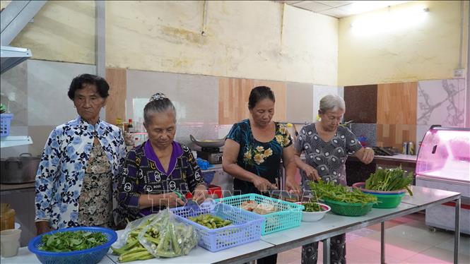 Những tình nguyện viên của Hội Chữ thập đỏ Vòng Tay nhân ái đang chuẩn bị các suất ăn trưa cho người nghèo. Ảnh: Văn Sĩ -TTXVN       