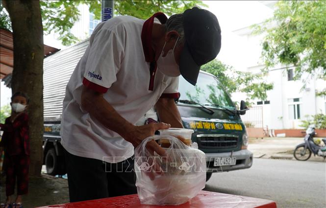 Khách đến ăn và nhận cơm từ quán chay 5.000 đồng, quán cơm 0 đồng thường là những người bán vé số, công nhân lao động có thu nhập thấp. Ảnh: Văn Sĩ -TTXVN          