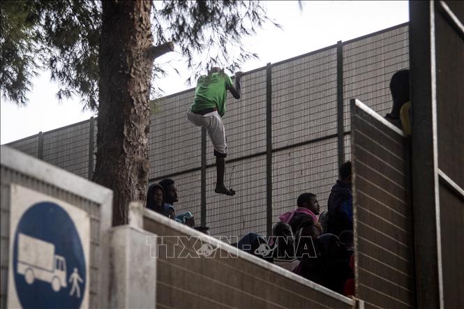 Người di cư tìm cách trốn khỏi trung tâm tiếp nhận và tạm giữ người di cư trên đảo Lampedusa, Italy, ngày 14/9/2023. Ảnh: AFP/TTXVN
