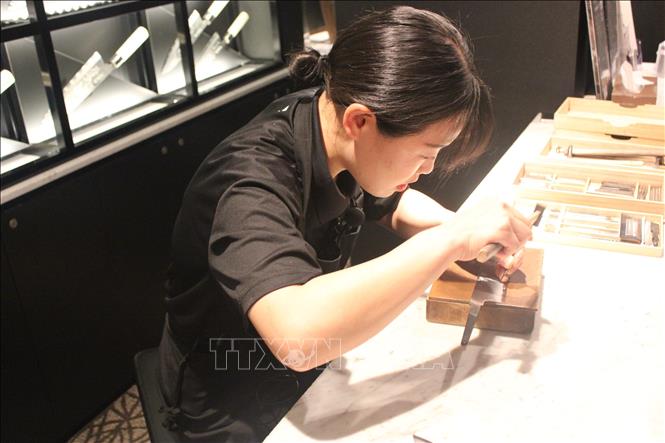 Nghệ nhân Michiko Kubota khắc chìm trên dao Sakai. Ảnh: Phạm Tuân - PV TTXVN tại Nhật Bản