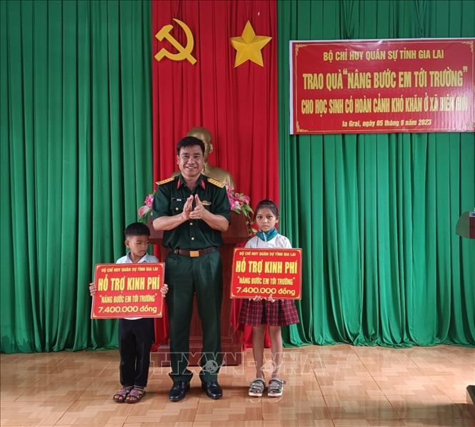 Đại tá Ksơr Lành, Phó Chính ủy Bộ Chỉ huy quân sự tỉnh Gia Lai tặng quà cho các em học sinh tại xã Ia Chía, huyện Ia Grai, tỉnh Gia Lai. Ảnh: Hồng Điệp - TTXVN