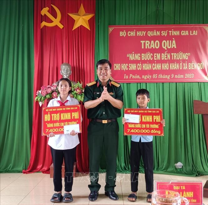 Đại tá Ksơr Lành, Phó Chính ủy Bộ Chỉ huy quân sự tỉnh Gia Lai tặng quà cho các em học sinh tại xã Ia Pnôn, huyện Đức Cơ, tỉnh Gia Lai. Ảnh: Hồng Điệp - TTXVN 