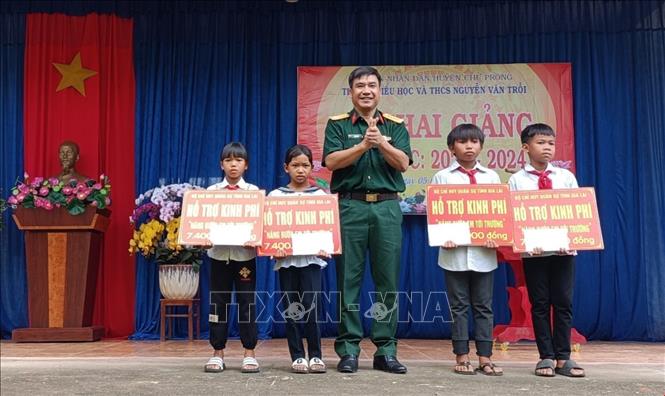 Đại tá Ksơr Lành, Phó Chính ủy Bộ Chỉ huy quân sự tỉnh Gia Lai, tặng quà cho các em học sinh tại xã Ia Mơr, huyện Chư Prông, tỉnh Gia Lai. Ảnh: Hồng Điệp - TTXVN