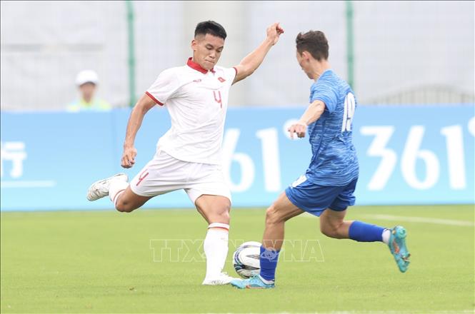 Player Nguyen Manh Hung (No. 4, white shirt) kicks the ball to bypass Mongolian defender. NA Photo: Hoàng Linh