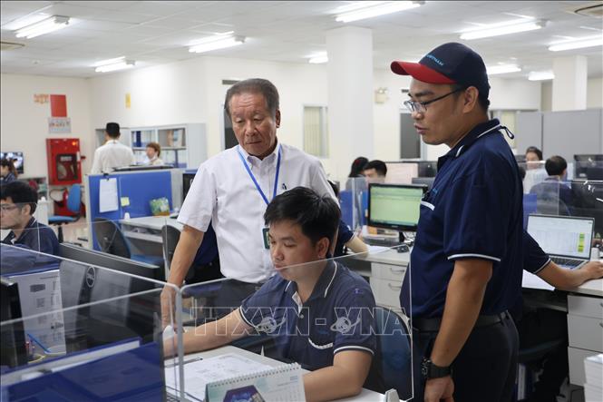 Ông Kazuhisa Fukuo (đứng, trái), Tổng giám đốc Công ty TNHH TAZMO VIETNAM, chỉ đạo kỹ sư thiết kế thiết bị robot. Ảnh: Minh Hưng – TTXVN