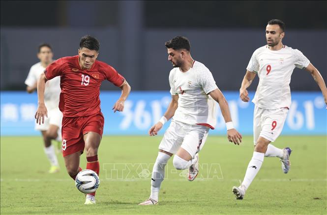 Cầu thủ Nguyên Hoàng (đội tuyển Olympic Việt Nam, số 19) đi bóng trước sự truy cản của hậu vệ Olympic Iran. Ảnh: Hoàng Linh-TTXVN