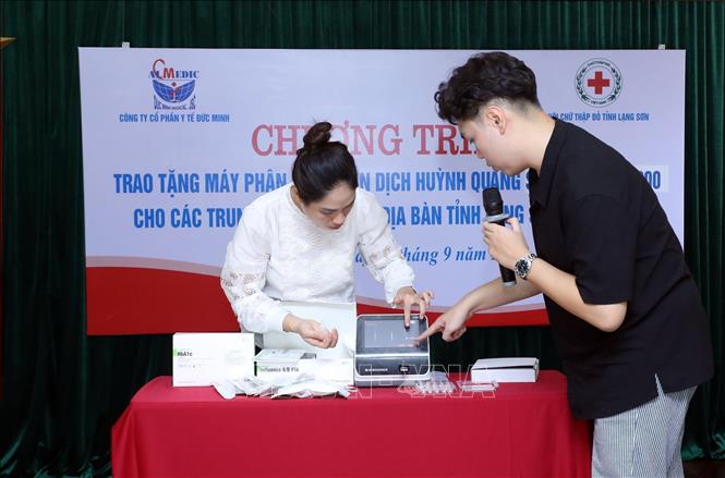 Nhân viên Công ty Cổ phần Y tế Đức Minh hướng dẫn các cán bộ Trung tâm Y tế trên địa bàn tỉnh sử dụng máy phân tích miễn dịch huỳnh quang Standard TM F200 tại Chương trình. Ảnh: Anh Tuấn – TTXVN