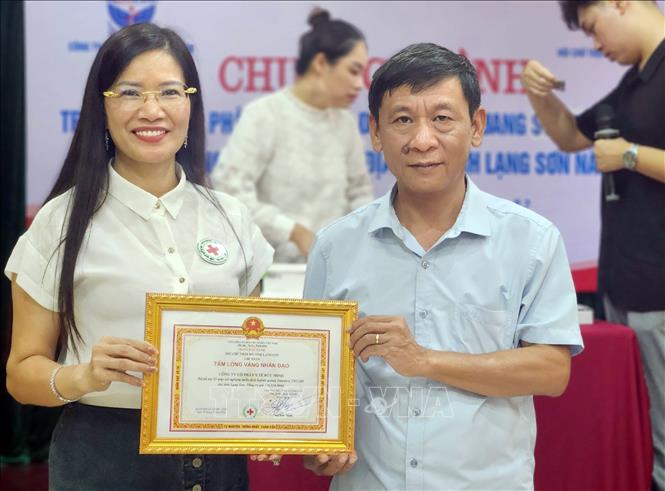 Chủ tịch Hội Chữ thập đỏ tỉnh Lạng Sơn Nông Bích Thuận tặng bảng Tấm lòng vàng cho Công ty Cổ phần Y tế Đức Minh đã tài trợ vật tư y tế cho tỉnh Lạng Sơn. Ảnh: Anh Tuấn – TTXVN