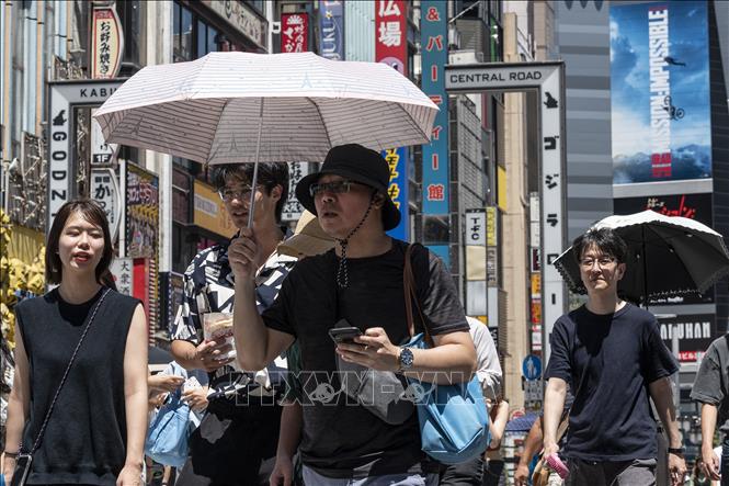 Người dân di chuyển dưới trời nắng nóng tại Tokyo, Nhật Bản ngày 30/7/2023. Ảnh: AFP/TTXVN