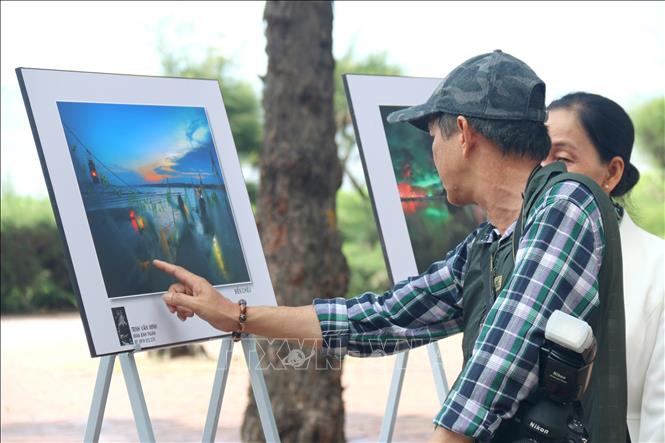 Đại biểu và du khách xem triển lãm ảnh nghệ thuật Nét đẹp sắc màu Bình Thuận tại công viên Đồi Dương, thành phố Phan Thiết. Ảnh: Nguyễn Thanh - TTXVN