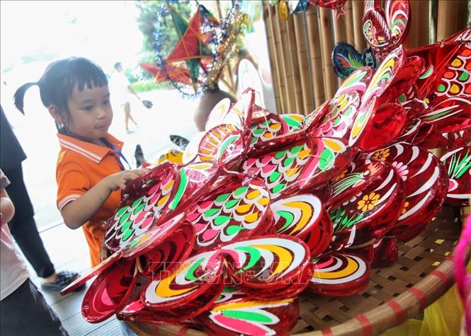 Em nhỏ cùng các món đồ chơi Trung thu truyền thống. Ảnh: Tuấn Đức - TTXVN