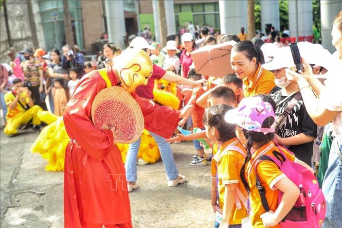Câc em nhỏ tương tác với ông địa tại tiết mục múa lân. Ảnh: Tuấn Đức - TTXVN