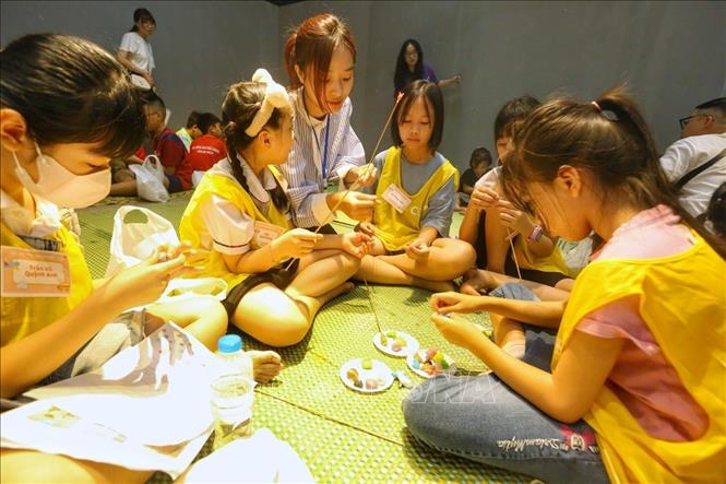 Các em nhỏ trải nghiệm làm tò he. Ảnh: Tuấn Đức - TTXVN