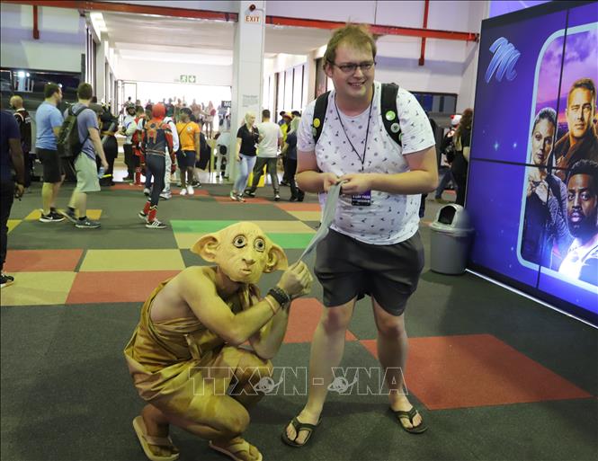 Khách tham quan tại Comic Con Africa 2023 chụp ảnh lưu niệm cùng nhân vật yêu tinh Dobby trong loạt truyện Harry Porter. Ảnh: Hồng Minh - Pv TTXVN tại Nam Phi