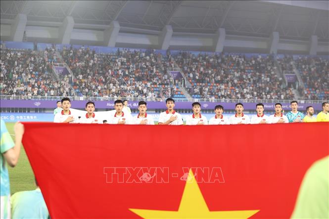Các tuyển thủ Olympic Việt Nam làm lễ chào cờ. Ảnh: Hoàng Linh - TTXVN