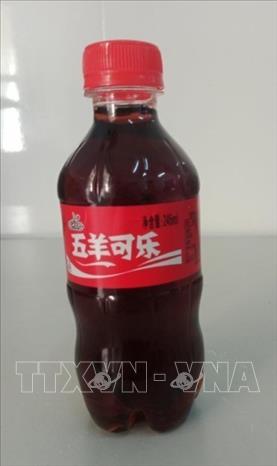 Chai nước ngọt có in chữ Trung Quốc không rõ nguồn gốc xuất xứ mà các học sinh mua ở cổng trường. Ảnh: TTXVN phát