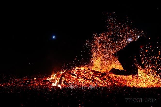Sau khi được thầy cúng làm lễ, người thanh niên nhảy bật lên bằng cả hai chân và lao vào giữa đống lửa cháy rừng rực mà không bị bỏng (Tuyên Quang, 2023). Ảnh: Nam Sương - TTXVN