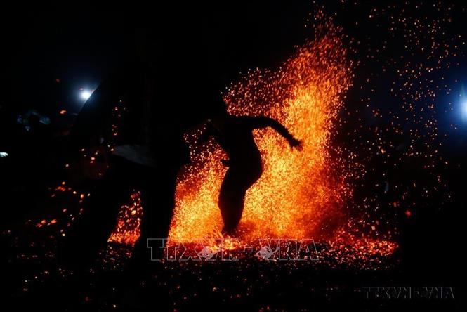 Không có bất cứ một vật dụng nào để lót cho đôi chân của những chàng trai Pà Thẻn khi nhảy lửa (Tuyên Quang, 2023). Ảnh: Nam Sương - TTXVN