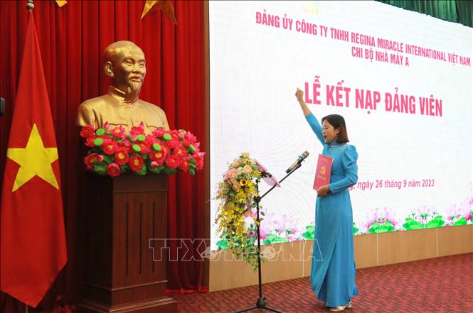 Đảng viên Công ty TNHH Regina Miracle International Việt Nam tuyên thệ tại lễ kết nạp. Ảnh: Minh Thu- TTXVN