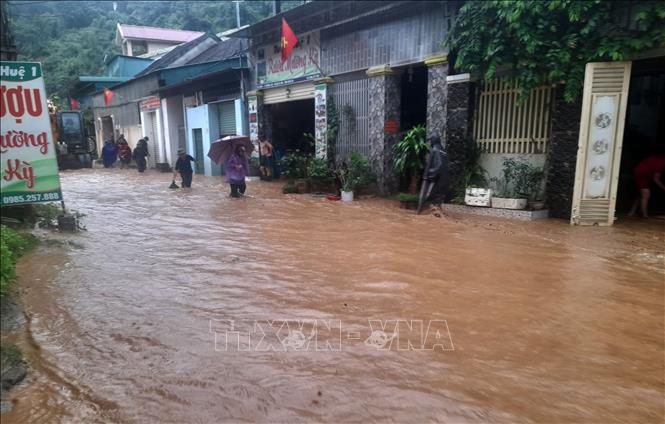 Nhiều nhà dân và các cơ quan đơn vị tại khối 1 thị trấn Mường Xén, huyện Kỳ Sơn bị chia cắt do nước lũ chảy xiết. Ảnh: TTXVN phát