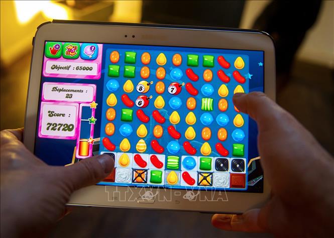 Người dùng chơi Candy Crush Saga trên máy tính bảng tại Lille, Pháp. Ảnh: AFP/TTXVN