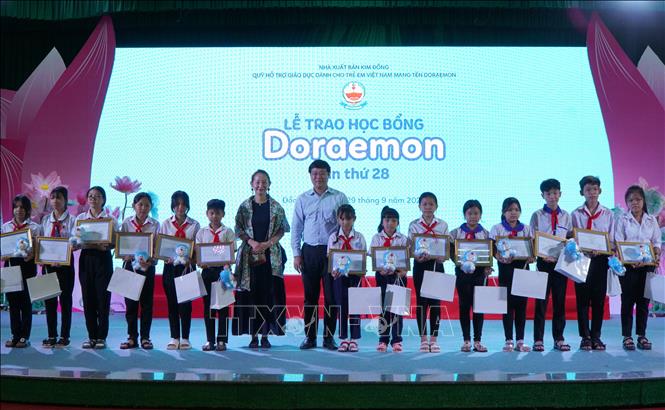 Trao học bổng Doraemon cho học sinh vượt khó học tốt. Ảnh: Nhựt An - TTXVN