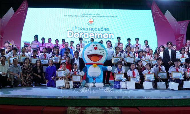 Các học sinh vượt khó học tốt được nhận học bổng Doraemon. Ảnh: Nhựt An - TTXVN