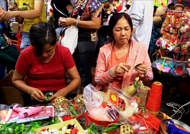 Craftswomen make hand-made lanterns on Luong Nhu Hoc street. VNA Photo: Hồng Đạt 