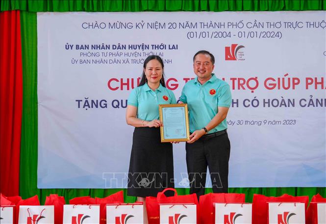 Ông Huỳnh Văn Tùng, Phó Bí thư thường trực Huyện ủy Thới Lai trao Thư cảm ơn cho PGS.TS Nguyễn Minh Hằng, Phó Giám đốc Học viện Tư pháp. Ảnh: Thanh Liêm - TTXVN