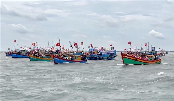 Các đoàn ghe tháp tùng thuyền Nghinh Ông trên biển. Ảnh: Thu Hương - TTXVN