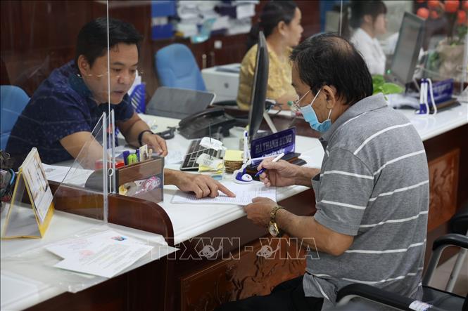 Cán bộ Trung tâm Phục vụ hành chính công tỉnh Long An hướng dẫn người dân hoàn tất các thủ tục hành chính. Ảnh: Minh Hưng – TTXVN 
