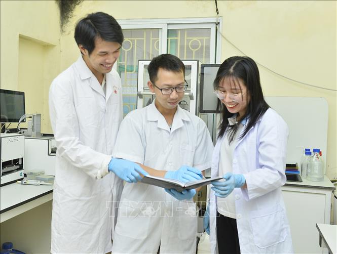 Tiến sĩ Ngô Ngọc Hải trao đổi công việc cùng các đồng nghiệp. Ảnh: Minh Đức – TTXVN

