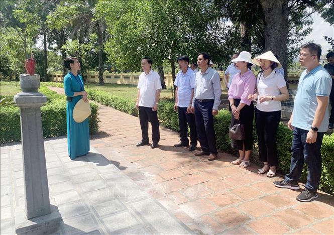 Hướng dẫn viên giới thiệu cho du khách các giá trị văn hóa, lịch sử của Khu di tích Nguyễn Du. Ảnh: Hữu Quyết - TTXVN
