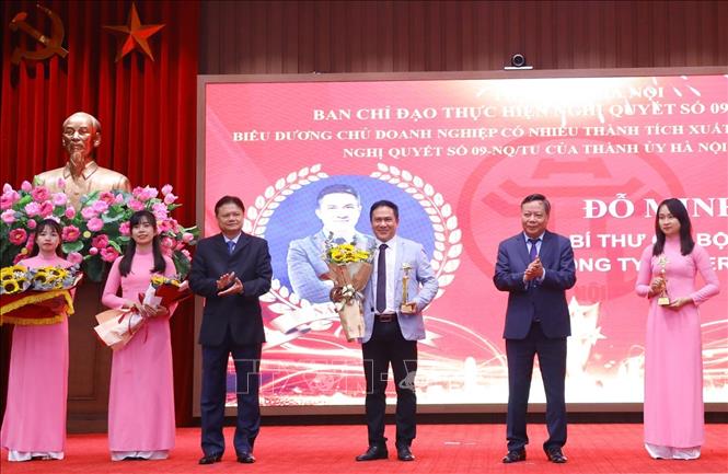 Phó Bí thư Thành ủy Hà Nội Nguyễn Văn Phong (bên phải) và Trưởng Ban Tổ chức Thành ủy Vũ Đức Bảo (bên trái) trao biểu trưng và hoa tặng các chủ doanh nghiệp. Ảnh: Văn Điệp - TTXVN