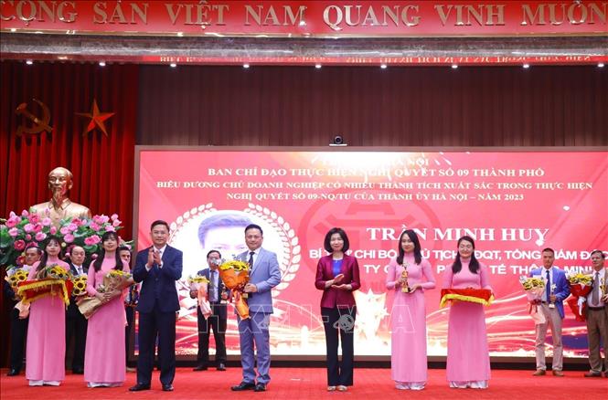 Phó Chủ tịch HĐND TP Hà Nội Phùng Thị Hồng Hà (bên phải) và Phó Chủ tịch UBND thành phố Hà Nội Hà Minh Hải (bên trái) trao biểu trưng và hoa tặng các chủ doanh nghiệp. Ảnh: Văn Điệp - TTXVN