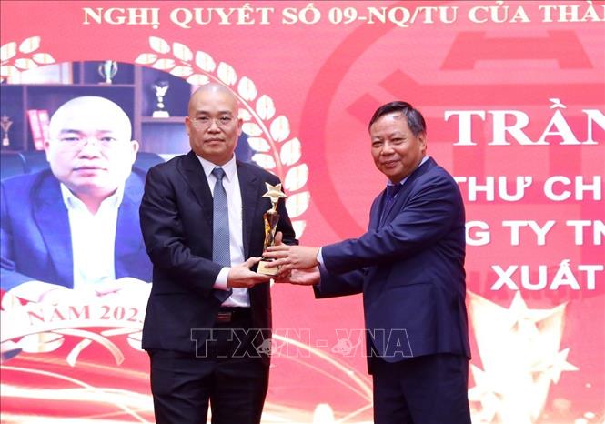 Phó Bí thư Thành ủy Hà Nội Nguyễn Văn Phong trao biểu trưng tặng các chủ doanh nghiệp. Ảnh: Văn Điệp - TTXVN