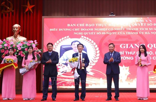 Phó Bí thư Thành ủy Hà Nội Nguyễn Văn Phong (bên phải) và Trưởng Ban Tổ chức Thành ủy Vũ Đức Bảo (bên trái) trao biểu trưng và hoa tặng các chủ doanh nghiệp. Ảnh: Văn Điệp - TTXVN