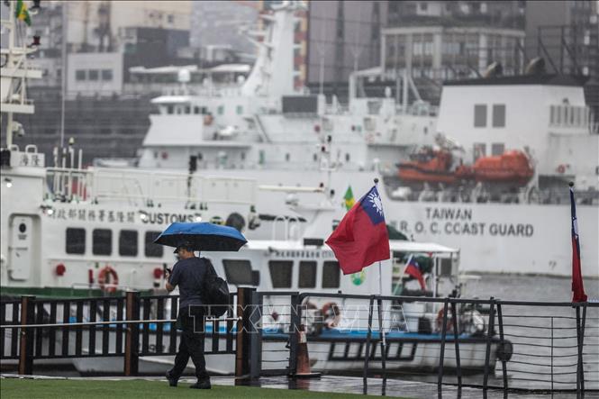 Người dân di chuyển trong mưa do ảnh hưởng của bão Koinu ở thành phố Cơ Long, vùng lãnh thổ Đài Loan (Trung Quốc), ngày 5/10/2023. Ảnh: AFP/TTXVN