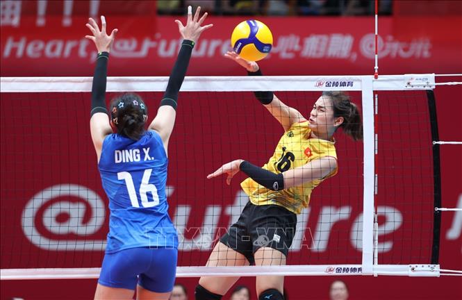 Như Quỳnh (16) đập bóng trước sự cản phá của đối thủ Trung Quốc. Ảnh: Hoàng Linh-TTXVN